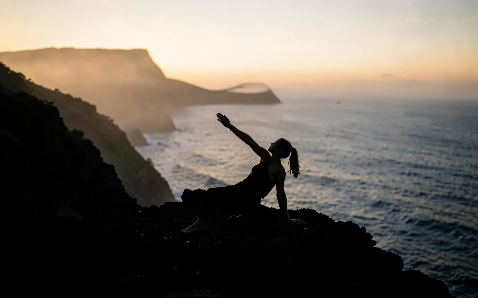 Yoga at dawn on a volcanic cliff in the Azores
